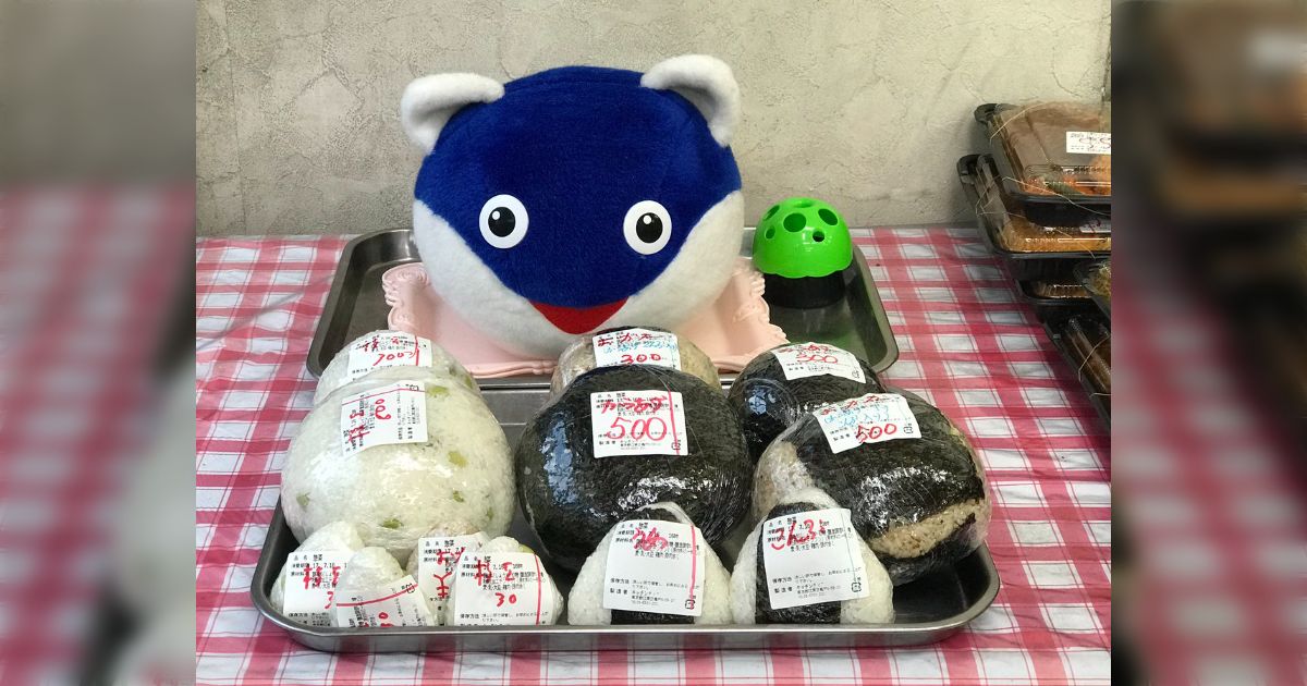 店内のぬいぐるみを見て商品に巨大おにぎりがある理由を察する人々